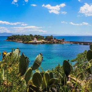 Gythio - May 2019. Close to the harbour in Gythio is the small islet of Kranae. Walk onto the islet and you will find the lighthouse and the Tzanetakis tower. If you sit by the church you will be offered gorgeous views of the snow capped Teygettus mountain range behind the town. More importantly, Kranae island is where Paris and Helen were said to have departed for Troy!