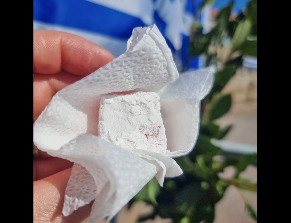 Lesvos 2022 Woman offering loukoumi during the Oxi Day celebrations in Molyvos.