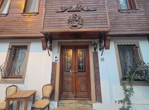 Vineyard reference in arhcitecture Door and sachnisi adorned with wooden reliefs of grapes signifying Bozcaadas winemaking heritage